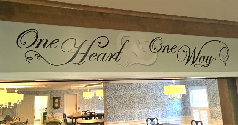 Hand painted motto over dining room archway.