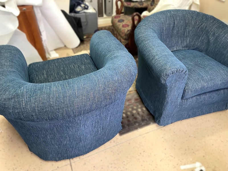 Matching pair of slipcovered club swivel chairs.