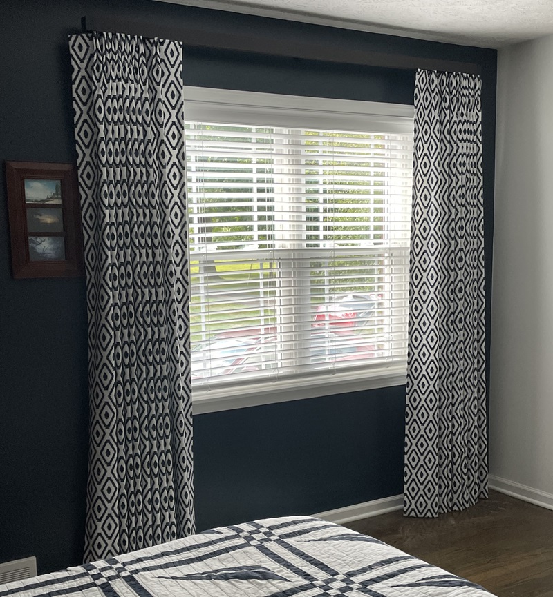 Unique embroidered navy and white draperies on square pole.